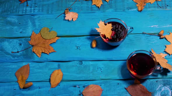 The Leaves Fall On The Table And Into The Tea Cup. Beautiful Autumn Background With Yellow Foliage