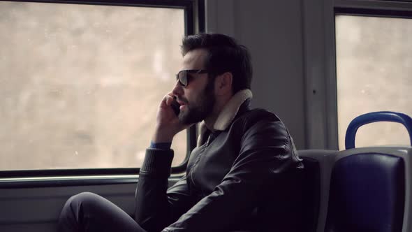 Man In Sunglasses Using Mobile Phone And Call To Friends. Man Talking On Smartphone In Train. alt
