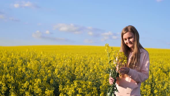 Happy Young Blonde on a Yellow Rapeseed Field alt