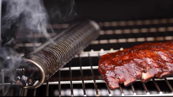 Close up of smoker and ribs pan of baby back pork rub and sauced ribs Concept: BBQ, Smoker, outside alt
