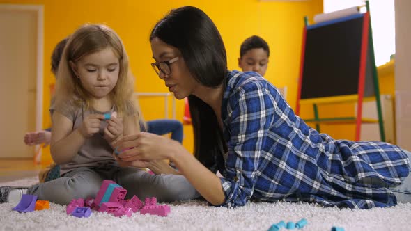 Teacher and Cute Girl Communicating in Kindergarten alt