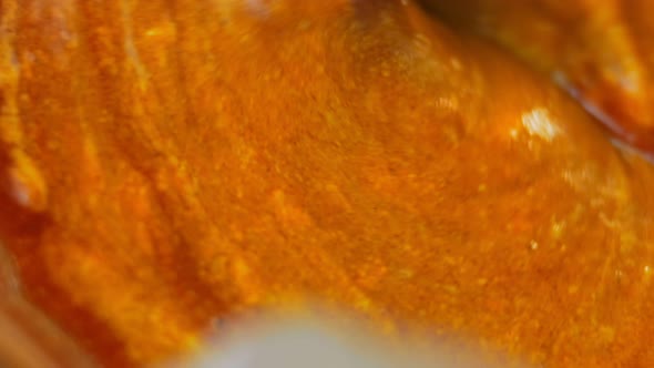 The Chef Mixes the Ingredients for the Honey and Mustard Sauce with a Golden Spoon alt