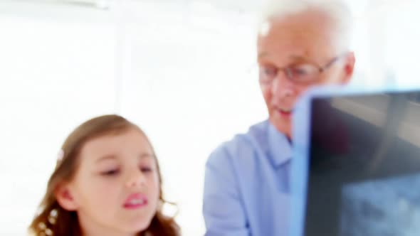 Male doctor and patient looking at x-ray alt
