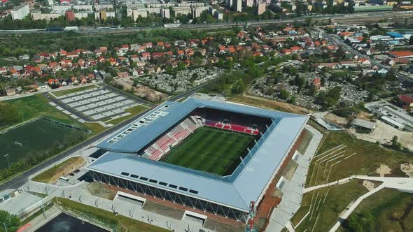 Midday and moving slowly forward drone view near the top of the open roofed soccer stadium. ( DJi Dr alt