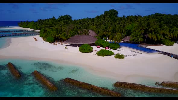 Aerial drone shot tourism of luxury shore beach holiday by blue green lagoon with white sand backgro alt