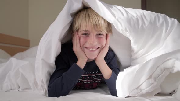 Funny kid under blanket at the morning. alt
