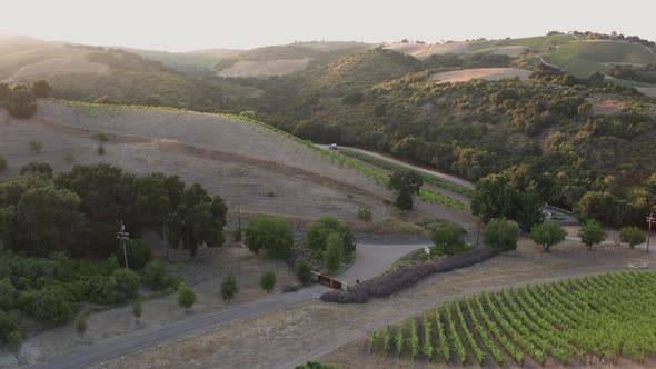 Aerial Drone Shot of a House in a Valley Surrounded by Vineyards During Sunset (Paso Robles,CA)