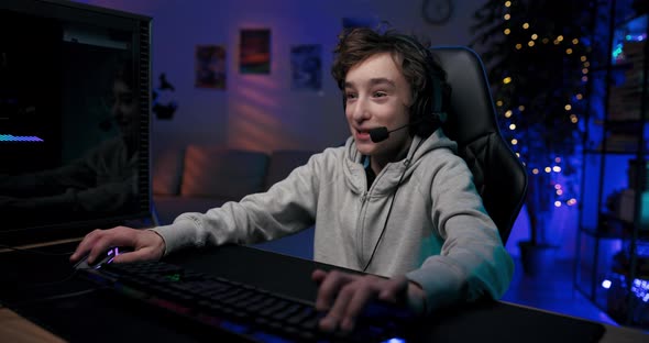 A Professional Gamer is Live Streaming a Game for Fans on Social Media Talking to Team Through a alt