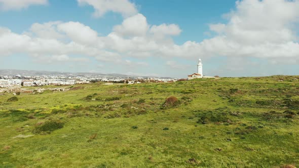 Drone View of White Lighthouse and Paphos City, Cyprus with Mountains and Sky on Background alt