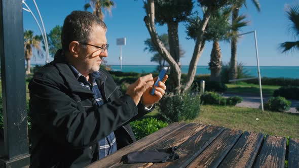 Portrait of Senior Man Cleaning Eye Glasses