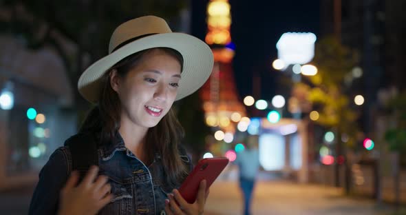 Woman use of mobile phone in Tokyo city at night alt