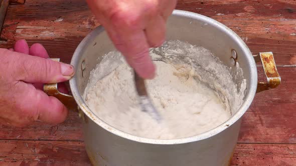 Stir flour dough with a pancake spoon. 