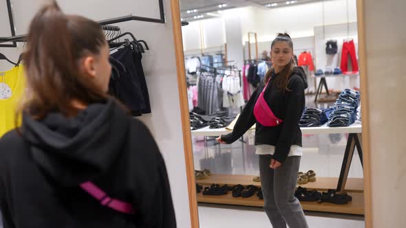 Pretty Young Woman Shopping in Clothes Store alt
