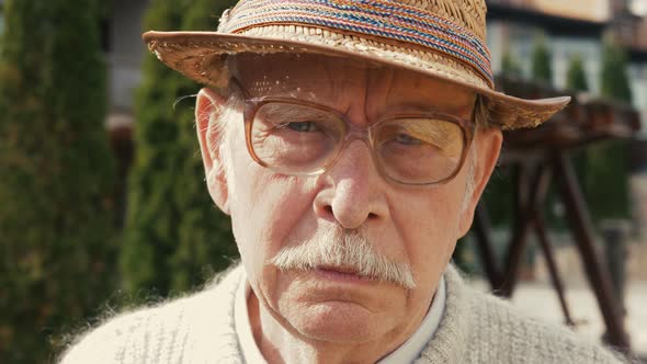 Portrait shot of the senior Caucasian man with grey hair mustache and looking straight to the camera