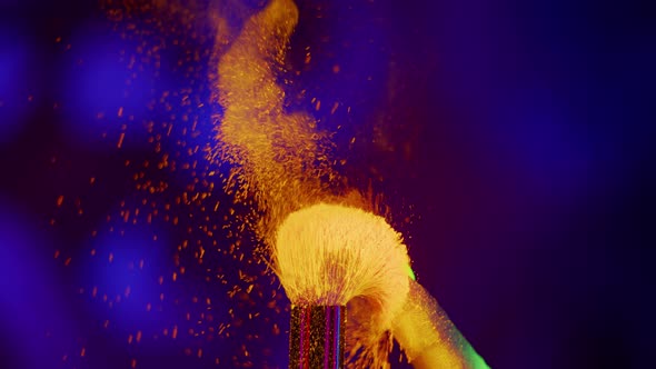 Glowing Neon UV Powder on a Makeup Brush Flying Away with Woman Finger Flicking on Neon Background