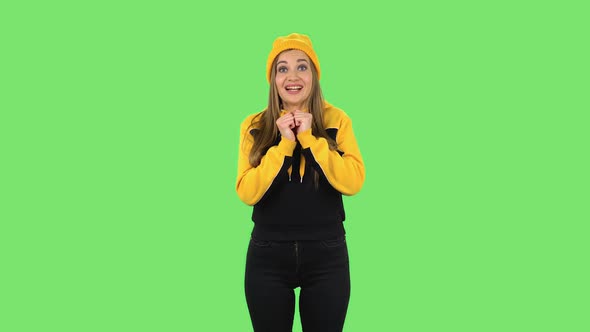 Modern Girl in Yellow Hat Is Looking at Camera with Anticipation, Then Very Upset. Green Screen alt