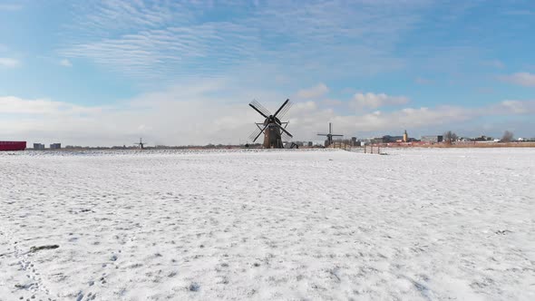 Winter Dutch windmill scenery, aerial view over snowy polders alt