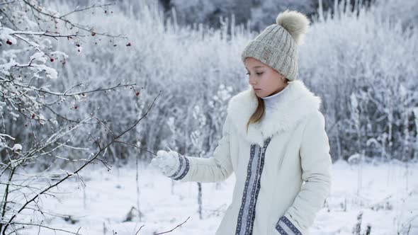 Beautiful Pensive Girl Touching Frozen Tree in Winter Forest alt