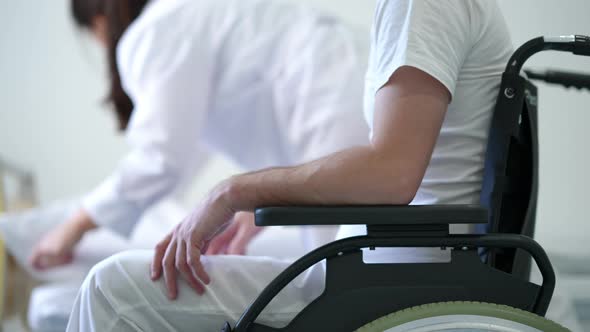 Unrecognizable Man in Wheelchair Waiting for Nurse Making Bed at Background alt