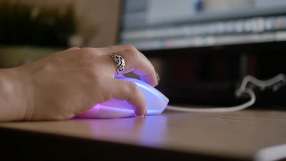 Female Hand with a Ring on the Finger Works with a Backlit Computer Mouse