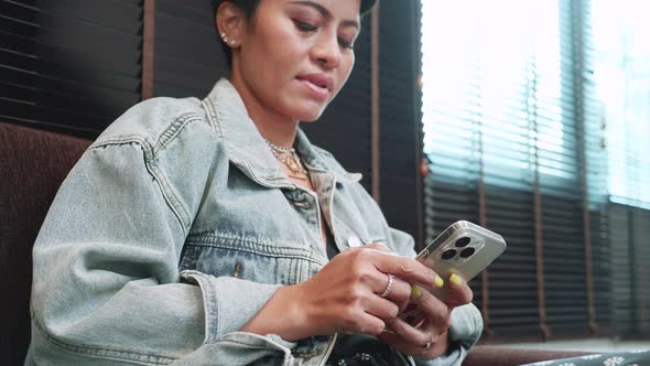 Businesswoman using smartphone, wait for boarding at empty lounge of domestic terminal alt