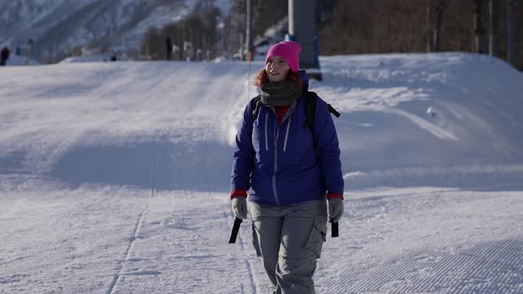 Sporty Traveller Woman is Walking in Ski Resort at Sunny Winter Day Happy Skier or Snowboarder alt