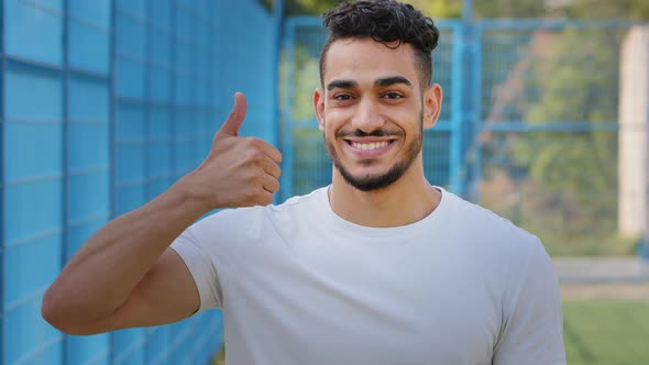 Cheerful Contented Middle Eastern Arabic Student Showing Thumbs Up Symbol Approval Support alt