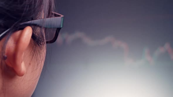 Young businesswoman working in office with red and green candlestick chart and stock trading. alt