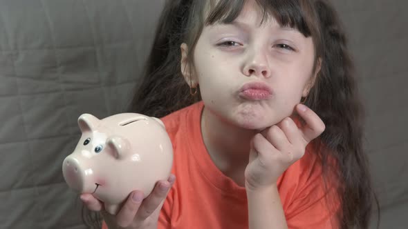Child with a piggy bank.  alt