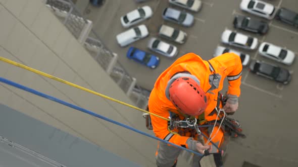 Industrial Climber in Suit and Helmet Prepares Sets Up Tread Protect It From Rubbing Against alt