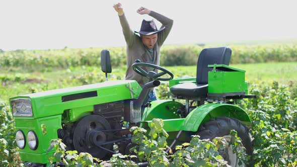 Young Happy Farmer Rejoices at His New Tractor alt