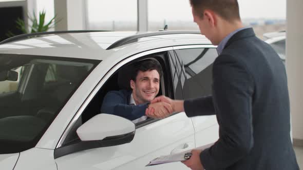 Car Sales Joyful New Vehicle Buyer Takes Keys From Auto Dealer in Automobile Showroom Successful