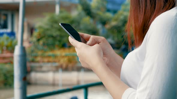 Using mobile phones send text messaging at a public park.