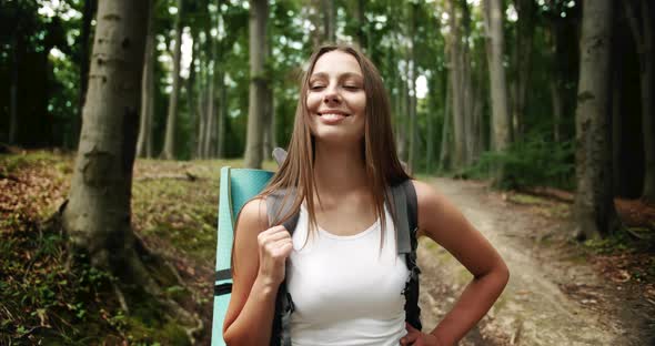 Portrait of Backpacked Woman in Forest