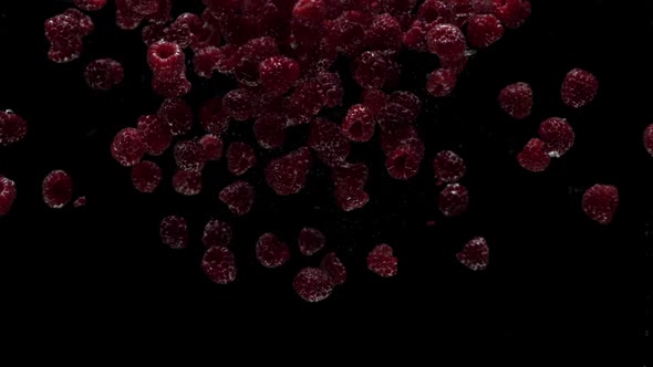 Slow Motion Raspberry Falling Into Transparent Water on Black Background alt