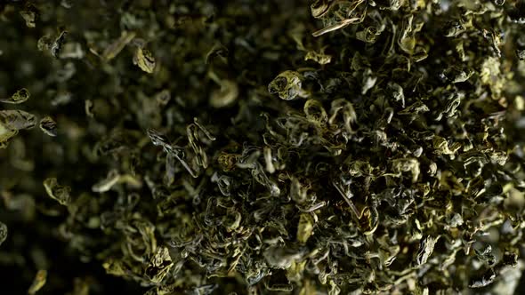 Super Slow Motion Shot of Dried Green Tea Explosion Isolated on Black Background at 1000Fps alt
