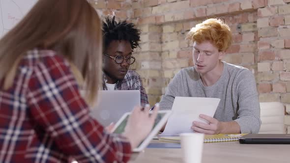 Group of Young Multiethnic Colleagues Sitting in Office and Discussing Project. Portrait of alt