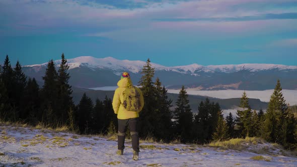 A Man with a Backpack Travels in the Mountains in Winter alt
