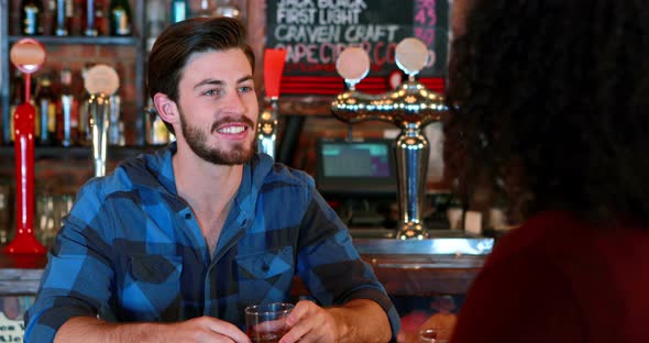 Friends interacting while having whisky alt