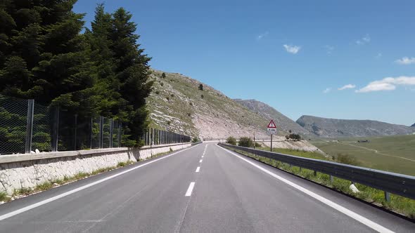 Moving view (car, motorbike or bicycle) of a mountain landscape