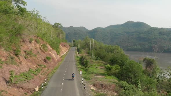 Aerial view of Motorcyclist on road next to Mekong River, Laos  alt