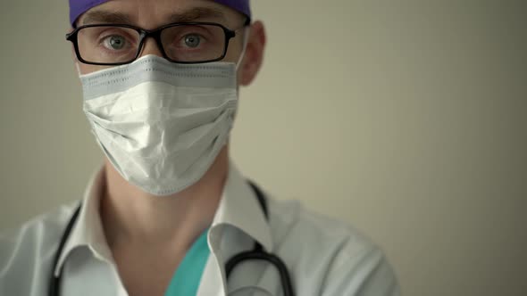 Masked Medical Professional Looks into the Camera alt