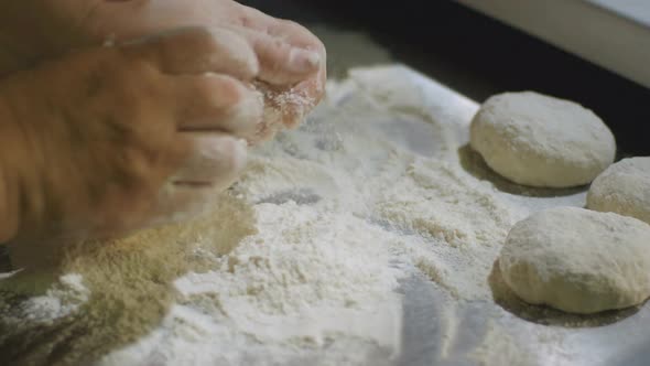 Closeup Human Hands Knead Dough on Board with Flour alt