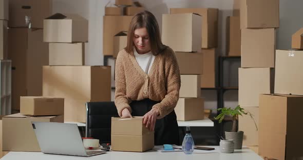 Woman Is Unpacking Box with Cosmetic in Home Warehouse Small Trading or Supplying Company Business alt