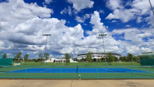 Time-lapse of outdoor empty tennis court with blue sky and cloud