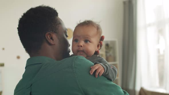 Father Holding His Child in Hands alt