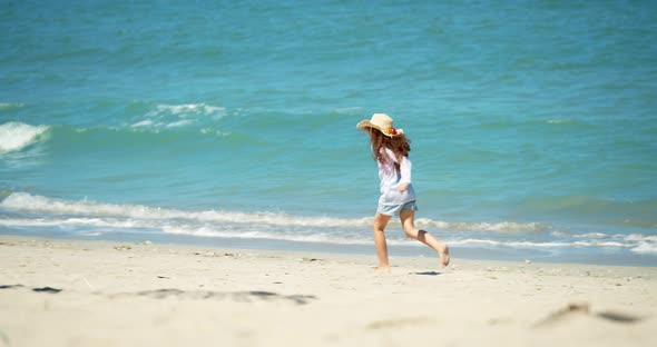A Funny Little Girl in a Hat Runs Along the Shore Along the Beach a Child on a Sunny Day By the Sea alt