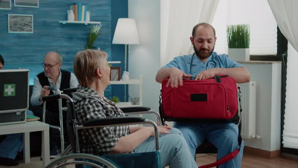 Senior Woman in Wheelchair Getting Medical Visit at Nursing Home alt