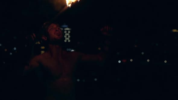 Young Blond Male Breathes Out Large Stream of Fire Multiple Times Making Fireballs Slow Motion alt