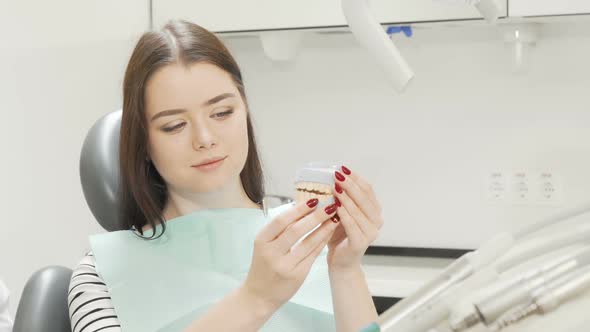 Happy Young Beautiful Woman Holding Dental Model Smiling To the Camera